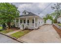 Inviting white home with a covered front porch, a long driveway, and detached garage at 1555 New Ne St, Atlanta, GA 30307