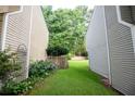 Side yard of a townhome featuring lush greenery, a wooden fence, and colorful flowers at 3053 Shadow Walk Ln, Tucker, GA 30084