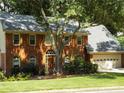 Beautiful brick home with mature trees, a well-manicured lawn, and two-car garage at 10815 Tuxford Dr, Alpharetta, GA 30022