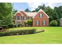 Charming brick home with manicured lawn and mature landscaping featuring black window shutters at 3045 Moss Stone Lane Sw Ln, Marietta, GA 30064