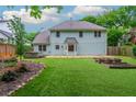 Spacious backyard with green lawn, a stone patio, a hot tub, and planting beds at 10980 Pinehigh Dr, Alpharetta, GA 30022