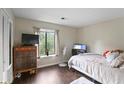 Comfortable bedroom with dark wood floor, a large window, and light colored walls at 1271 Muirforest Ln, Stone Mountain, GA 30088
