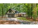 Expansive home with two car garage, black window trim and a manicured front lawn at 6486 Aquila Dr, Morrow, GA 30260