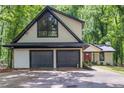Exterior of home showing attached two-car garage with black doors and updated black trim at 6486 Aquila Dr, Morrow, GA 30260