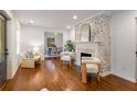 Bright living room boasts a decorative brick fireplace, hardwood floors, and stylish, comfortable seating at 814 S Mcdonough St, Decatur, GA 30030