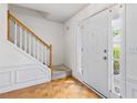 Inviting foyer with wood floors and a staircase, next to the home's front door at 11885 Carriage Park Ln, Duluth, GA 30097