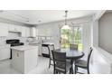 Bright kitchen and breakfast nook features white cabinets, black appliances, and sliding glass doors at 11885 Carriage Park Ln, Duluth, GA 30097