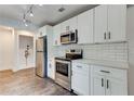 The kitchen features stainless steel appliances, a subway tile backsplash, and white cabinetry at 1914 North Nw Ave, Atlanta, GA 30318