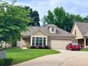 Inviting one-story home featuring manicured landscaping, stone detailing, and a paved driveway at 245 Fenwick Cir, Mcdonough, GA 30253