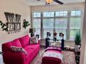 Cozy sunroom with large windows, bright pink sofa, and decorative accents at 245 Fenwick Cir, Mcdonough, GA 30253