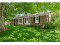 Charming brick home featuring a well-manicured lawn surrounded by mature trees and foliage at 2826 Summit Ridge Dr, Marietta, GA 30066