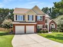 Inviting two-story home featuring a brick facade, manicured landscaping, and a spacious driveway leading to a two-car garage at 2740 Greymont Ct, Cumming, GA 30041