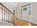 Bright foyer with hardwood floors, staircase with decorative iron spindles, and a view of the front door at 275 Springs Xing, Canton, GA 30114