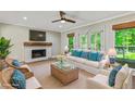 Bright living room features a fireplace, large windows, and comfortable seating at 115 Edgewater Way, Peachtree City, GA 30269