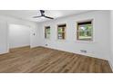 Bright living room featuring wood-look flooring, white walls, and three windows overlooking the front yard at 1400 North Avenue Nw, Atlanta, GA 30318