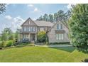 Beautiful two-story brick home with manicured lawn, elegant landscaping, and a welcoming front porch at 2380 Tayside Nw Xing, Kennesaw, GA 30152