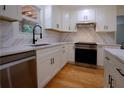 Beautiful kitchen featuring white cabinets, stainless steel appliances, marble countertops, and sleek, dark hardware at 260 Lakemont Dr, Roswell, GA 30075