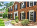 Close-up of a stately brick home featuring a well-manicured lawn and classic black shutters at 3506 Billingsley Dr, Marietta, GA 30062