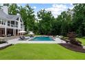 An in-ground pool is surrounded by ample patio space, lush greenery, and mature trees at 2101 Thomas Rd, Canton, GA 30115