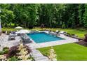 Gorgeous in-ground pool with a hot tub, outdoor seating, and lush landscaping at 2101 Thomas Rd, Canton, GA 30115