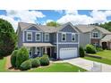 Beautiful home with a manicured lawn, lush greenery, and a two-car garage at 4003 Coachman Ct, Cumming, GA 30040