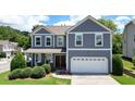 Inviting two-story home features a two-car garage and manicured front lawn at 4003 Coachman Ct, Cumming, GA 30040