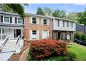 A charming brick townhome featuring a well-kept lawn and vibrant landscaping at 1481 Bentley Se Ln, Marietta, GA 30067