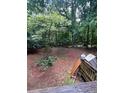 Extensive backyard with mature trees and a peek at the deck from the side of the yard at 974 Bloomfield Dr, Lawrenceville, GA 30044