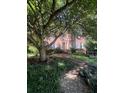Attractive brick home with mature trees, walkway, and traditional architectural details at 974 Bloomfield Dr, Lawrenceville, GA 30044