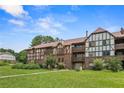 Multi-story condo featuring brick and Tudor style, with a lush green lawn at 124 Camelot Dr, Atlanta, GA 30349