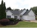 Picture of the front exterior of a well-kept one-story home with a paved driveway and green lawn at 550 Sessingham Ct, Alpharetta, GA 30005