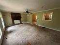 Living room with a brick fireplace, large window, and neutral-toned carpet, showing an open floor plan at 718 Hardy Way, Hiram, GA 30141