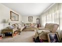Cozy living room with patterned sofas, a large window, and neutral carpeting at 6250 Graceland Cir, Morrow, GA 30260