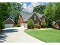 Spacious home featuring a three-car garage, driveway, and manicured lawn at 1464 Chatsworth Trace, Lawrenceville, GA 30044