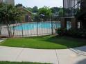 Community swimming pool is fenced with grass and concrete sidewalks at 898 Oak St Sw # 1311, Atlanta, GA 30310