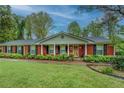 Attractive brick home with covered entryway, black shutters, and lush green landscaping at 1349 Springwood Nw Dr, Conyers, GA 30012