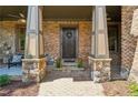 Welcoming front porch with stone columns and a cozy sitting area, perfect for enjoying the outdoors at 3405 Camellia Ln, Suwanee, GA 30024
