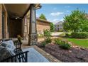 Comfortable front porch area with seating, landscaping and partial view of a neighboring house at 3405 Camellia Ln, Suwanee, GA 30024