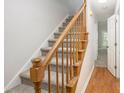 Carpeted staircase with wooden banister leading to the upper level of the home at 4098 Charlotte Se Ct, Smyrna, GA 30082