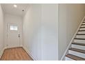 Foyer featuring wood-look floors, a stairway, and a white interior door at 685 Sunstone Ln, Lawrenceville, GA 30043