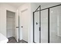 Modern bathroom featuring a glass-enclosed shower and linen closet at 699 Sunstone Ln, Lawrenceville, GA 30043