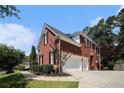 Brick home showing a two-car garage, side entry and well-manicured landscape at 351 Prestbury Ct, Suwanee, GA 30024