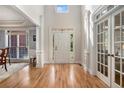 Bright foyer boasts hardwood floors and soaring ceilings and a glimpse into the dining room at 351 Prestbury Ct, Suwanee, GA 30024