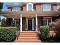 Inviting front porch with brick steps, pillars, and a decorative wreath on the front door at 351 Prestbury Ct, Suwanee, GA 30024