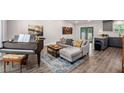 Open-concept living room features a piano, a grey couch, and an adjacent modern kitchen at 6176 Hyde Park Ln, Lithonia, GA 30058