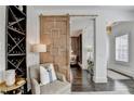 Dark wood floors and a unique barn door are the highlights of this foyer at 6399 Lucent Ln, Atlanta, GA 30328