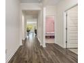 Inviting hallway with beautiful wood-look flooring, leading to various rooms and showcasing the home's layout at 2304 Pelham Pass, Dacula, GA 30019