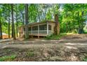 Beautiful exterior of the home featuring a spacious screened porch, chimney, and lush trees at 4323 Japonica Sw Ct, Lilburn, GA 30047