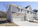 View of townhome showcasing brick accents, two-car garage, and neutral-tone siding at 913 Agate Ln, Lawrenceville, GA 30043
