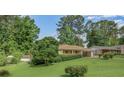 Single-story home with a brick facade, large front yard, and carport at 3563 Carriage Way, East Point, GA 30344